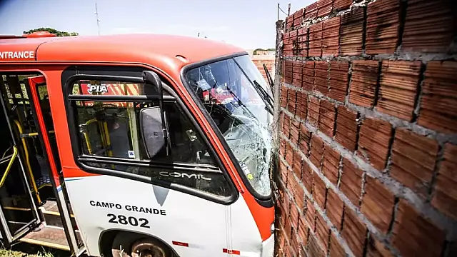 Motorista perde o controle ao passar em buraco e bate ônibus em muro