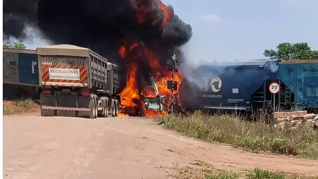 Carreta com calcário colide em trem, pega fogo e motorista sai ferido