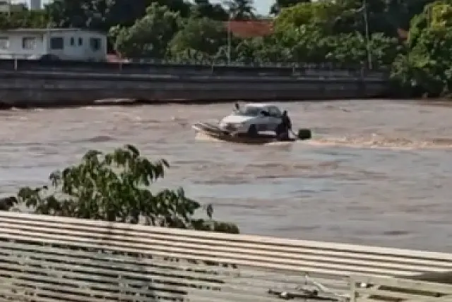 Ribeirinho atravessa veículo pelo Rio Taquari com ajuda de barco