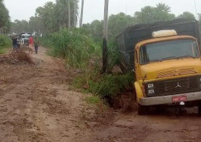 Caminhões atolam em estrada e só saem com ajuda de trator