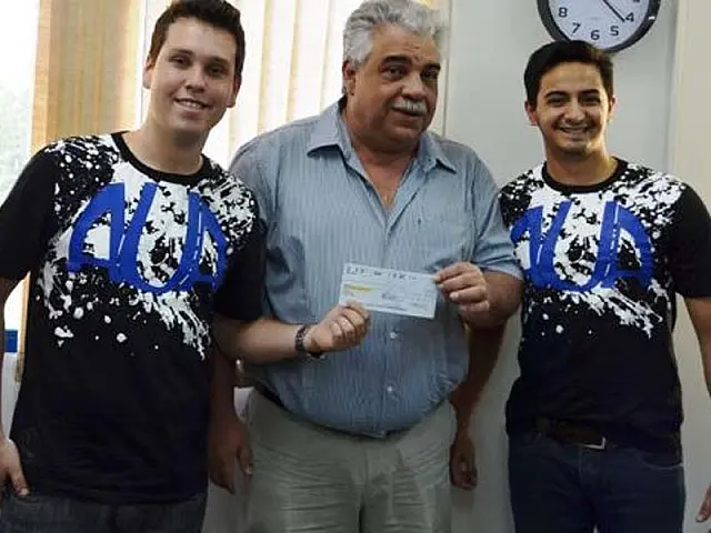 Representantes dos universitários recebem cheque do acordo de cooperação financeira