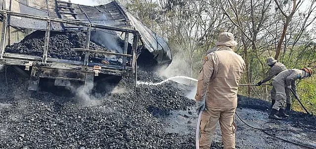 Caminhão carregado com carvão pega fogo após tombar na BR-262