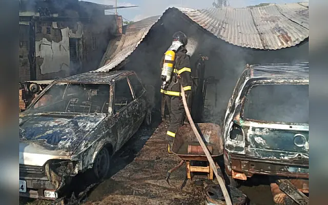 Bombeiros controlam fogo de mecânica completamente destruída