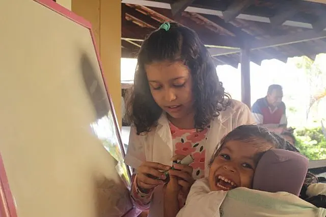 Menina inventa brincadeiras para fazer feliz quem tem paralisia cerebral