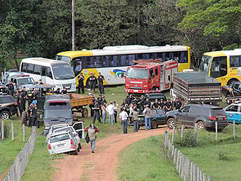 Viaturas e ônibus que levaram policiais à fazenda.